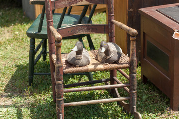 Two wooden duck on chair for sale at flea market