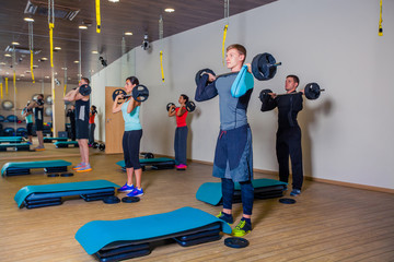 Obraz premium Sport, fitness, lifestyle and people concept - group flexing muscles with barbells in gym