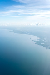 Aerial view of coastline against cloudy sky