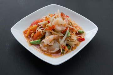 Green papaya salad (Som Tum) with shrimp on black background