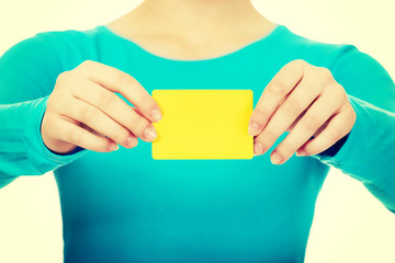 Young woman holding paper card.