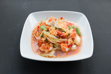 Green papaya salad with salted egg on wood table