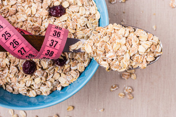 Oatmeal in bowl and measuring tape around spoon