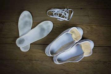White canvas shoes on wood background, still life