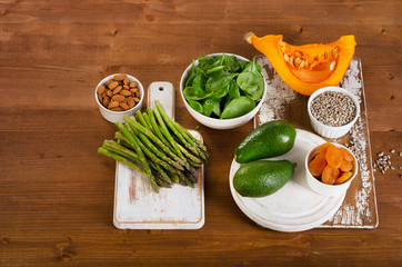 Foods containing vitamin E on a wooden background.