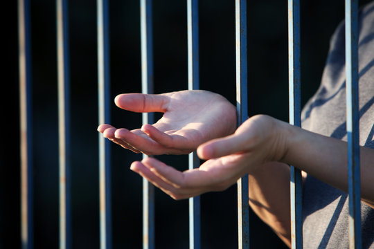 hand praying in jail