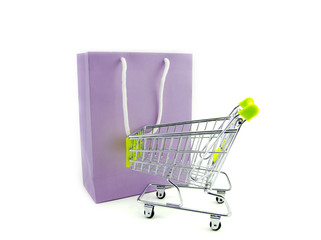 purple paper bag with shopping trolley isolated white background