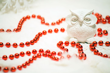 white ceramic owl and red beads in Christmas