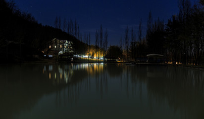 Reflected house in a lake at night in the mountains
