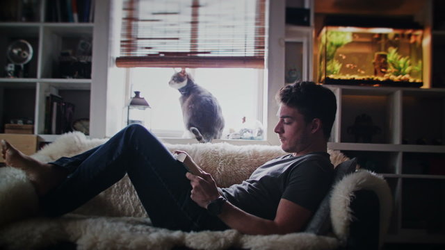 Cinemagraph (Photo-Motion) of a Young Relax Adult Reading a Book on the Couch