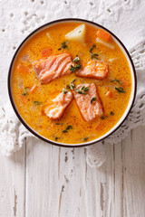 salmon soup with vegetables and thyme. vertical top view
