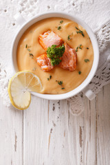 Salmon cream soup with lemon on the table. vertical top view
