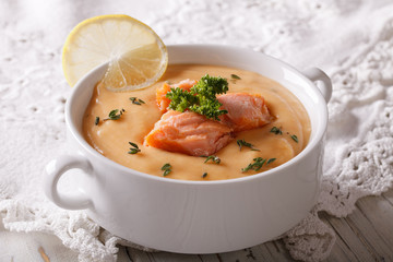 Salmon soup with lemon closeup on the table. horizontal
