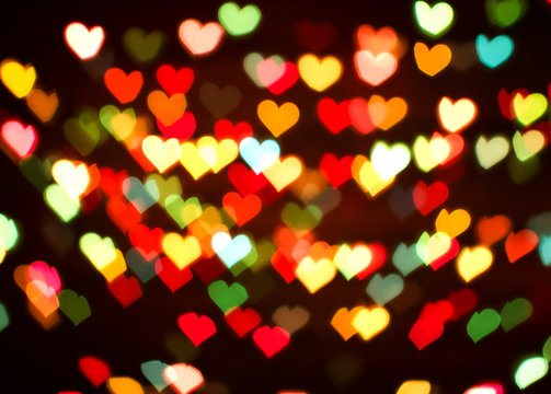Blurring lights bokeh background of colorful hearts