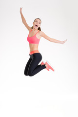 Fototapeta na wymiar Happy joyful young fitness woman jumping