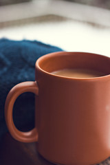A cup with a hot drink on the background of the winter forest