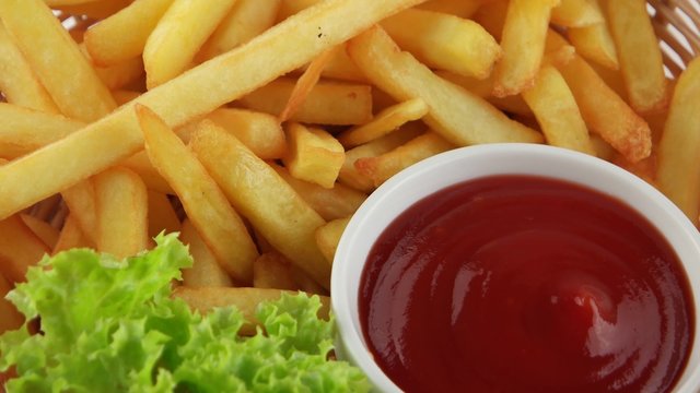 Fresh fried french fries with ketchup and leaf of salad (loop)