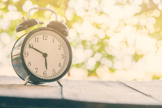 Retro alarm clock on bokeh background