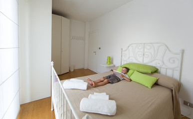 Bright room, bed and young child with tablet