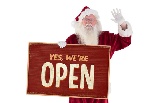 Composite image of santa holds a sign and is waving