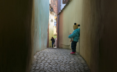 Obraz na płótnie Canvas little girl on String Street (Strada Sforii). it was built in the XVIIth century and it is considered to be one of the narrowest streets in Europe