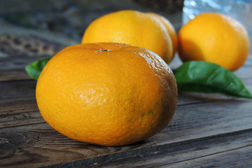 fresh mandarins with leafs on white wooden table