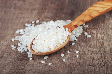  rice in wooden spoon on wooden background