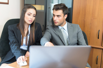 Smiling couple using a laptop computer