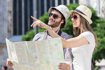 Happy tourists couple holding map
