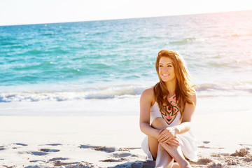 Fototapeta na wymiar Young woman sitting on the beach