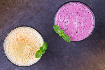 Frozen summer berries and banana milkshake garnished with mint. View from above, top studio shot