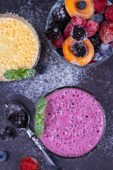 Frozen summer berries and banana milkshake garnished with mint. View from above, top studio shot