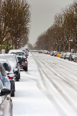 Fototapeta premium Parked cars lining a road covered in snow