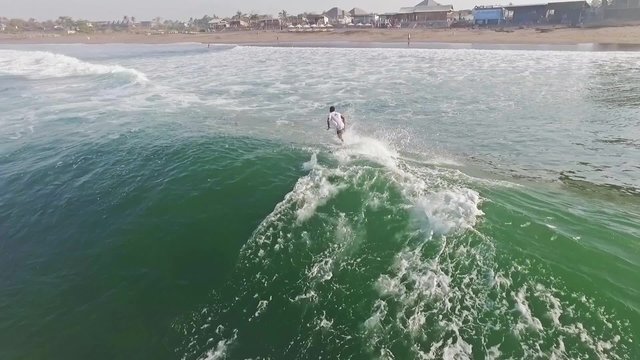 Aerial of a surfer on a mellow wave. Slow motion shot.
