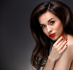 Beauty Model Woman with Long Brown Wavy Hair. Healthy Hair and Beautiful Professional Makeup. Red Lips and Smoky Eyes Make up. Gorgeous Glamour Lady Portrait. Haircare, Skincare concept