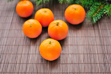 Tangerines and fir branches on table