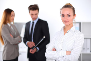 Pretty businesswoman in office with colleagues in the background