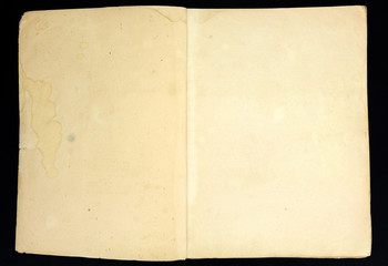 Old grunge book page, isolated on black background.