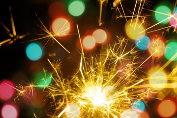 Bengal fire, sparkler and colorful bokeh christmas, new year background.