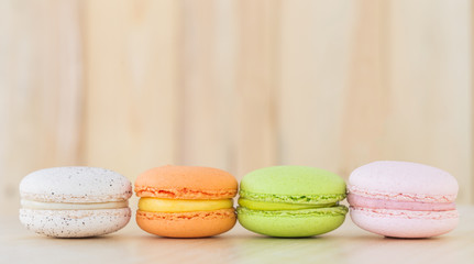 Colorful macarons on wooden background.