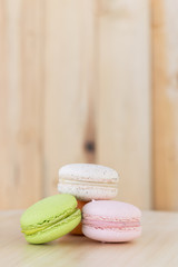 Colorful macarons on wooden background.