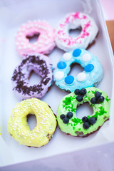 
sweets and colorful donuts in box