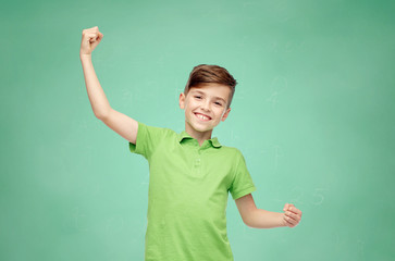 happy school boy in t-shirt showing strong fists