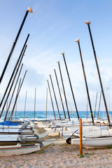 Sailing boats lay on the sandy beach in Calafell