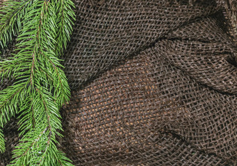 New design. Christmas design. On the sacking on the table green branch of fir or pine. Beads. Empty space for advertising and printing.