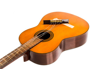 Fototapeta na wymiar Broken brown classical guitar with detached bridge from body isolated in white background