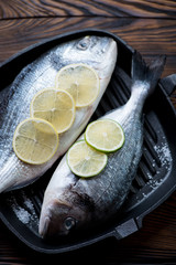 Closeup of two dorada fishes ready to be cooked, selective focus