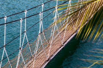 Obraz premium suspension bridge on the chains through the water