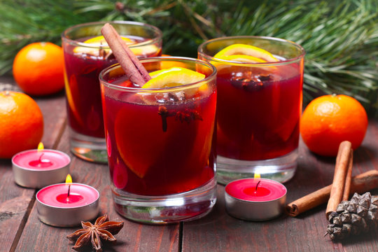 Christmas mulled wine in glasses with orange on wooden table, close up