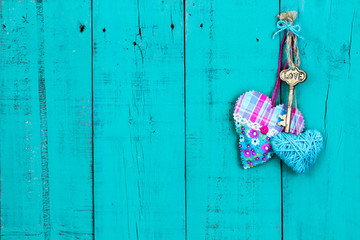 Skeleton key and fabric hearts hanging on wood door